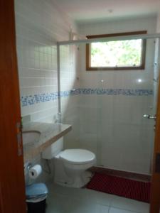 a bathroom with a toilet and a sink and a window at Maison Oceanic in Búzios