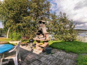 un four extérieur assis à côté d'une table et d'un gril dans l'établissement Holiday Home Joutsen by Interhome, à Verla 21 autres photos