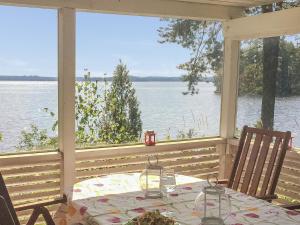 a table on a porch with a view of the water at Holiday Home Villa helge by Interhome in Savitaipale