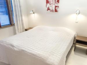 1 cama blanca en un dormitorio blanco con ventana en Holiday Home Tahko spa suites orange a 4 by Interhome, en Tahkovuori