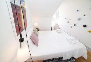 リスボンにあるFLH Bacalhoeiros River View Flatの白いベッドルーム(大型ベッド1台、窓付)