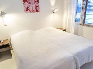 białe łóżko w białym pokoju z oknem w obiekcie Holiday Home Tahko spa suites orange a 4- price inclu by Interhome w mieście Tahkovuori