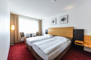 a bedroom with a large bed and a large window at City Hotel in Brunnen