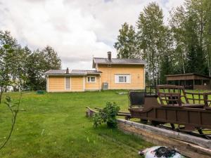 a yellow house in the middle of a yard at Holiday Home Joutsen by Interhome in Verla