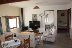 d'un salon avec un mobilier blanc et une télévision. dans l'établissement Gîtes Grand Pré ! et la Roulotte de Roquecor, à Roquecor