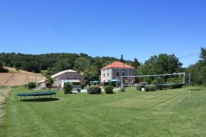 un campo con un gol de fútbol y una casa en Gîtes Grand Pré ! et la Roulotte de Roquecor en Roquecor
