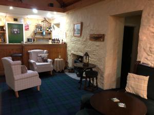 a living room with chairs and a table and a fireplace at The Shore House in Lochgoilhead