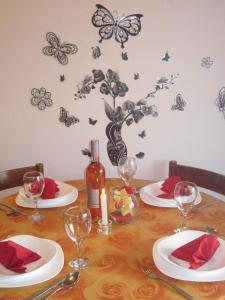 una mesa con platos y copas de vino y mariposas en la pared en APARTMANI KREŠIĆ 1 HVAR, en Hvar 26 fotos más