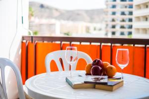 a table with two wine glasses and a plate of fruit at Guayero in Los Cristianos