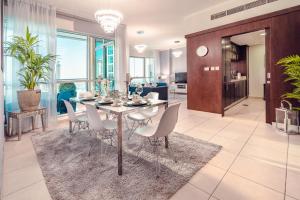 a dining room and living room with a table and chairs at Burj Grand Apartment - Four Bedrooms in Dubai