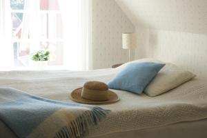 a hat sitting on top of a bed with a window at Svanebäcks gård in Viken