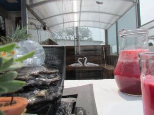 Hotel Apartasuite Normandia في بوغوتا: طاولة عليها مزهرية زجاجية ومشروب