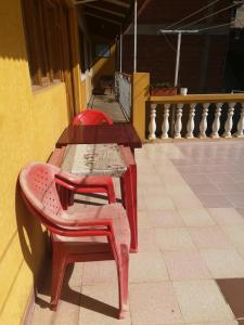 duas mesas com cadeiras vermelhas sentadas ao lado de um edifício em Homestay Jorge, Sucre em Sucre