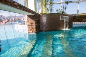 a swimming pool with a water fountain in a building at Hotel Terme Leonardo in Abano Terme +77 photos