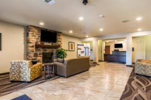 eine Lobby mit einem Sofa und einem Kamin in der Unterkunft Cobblestone Hotel & Suites - Torrington in Torrington