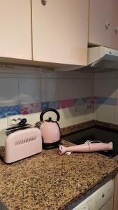 a pink toaster sitting on a counter next to a stove at Sol y Luz in Isla del Moral