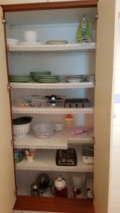 a cupboard filled with dishes and other kitchen items at Sol y Luz in Isla del Moral