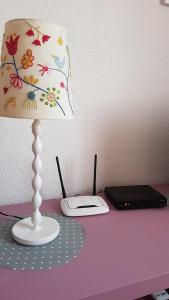 a lamp sitting on a purple desk with a laptop at Sol y Luz in Isla del Moral