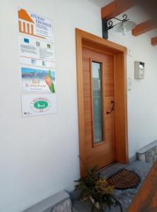 eine Tür zu einem Haus mit einem Plakat an der Wand in der Unterkunft B&B Il Tulipano in San Pietro di Cadore