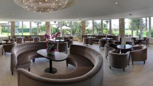 a restaurant with couches and tables and chairs at Hotel Terme Leonardo in Abano Terme