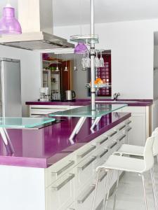 eine Küche mit lila Arbeitsplatten und weißen Schränken in der Unterkunft Alcazaba Beach Apartment 3302 in Estepona