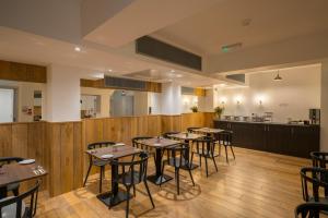 un comedor con mesas y un bar en Pelican London Hotel and Residence, en Londres