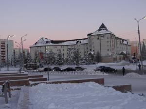 a large building with a lot of snow in front of it at Modus Apartment in Tobolsk