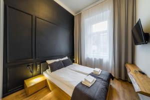 クラクフにあるOld Town, Loft Style Apartmentのベッドルーム1室(黒いヘッドボード付きのベッド1台付)