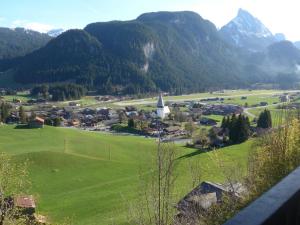 uma pequena cidade num campo verde com montanhas em Apartment Fluehüsli by Interhome em Gstaad