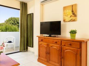 ein Wohnzimmer mit einem TV auf einer Holzkommode in der Unterkunft Apartment Euromar by Interhome in Torremolinos