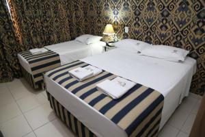 two beds in a hotel room with towels on them at CHA Royal Plaza Hotel in Apucarana +60 photos