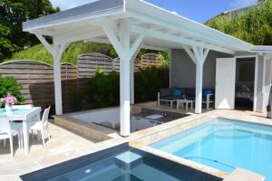 un padiglione sopra una piscina con tavolo e piscina di "Pépite" a Petit-Bourg