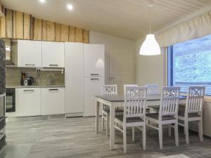 a kitchen with white cabinets and a table and chairs at Holiday Home Hilla b by Interhome in Saariselka
