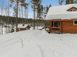 una cabaña de madera en la nieve con entrada en Holiday Home Vuorilahti by Interhome, en Savonranta