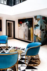 a lobby with blue chairs and a painting at Riad Dar Saba - Saba's House in Tangier