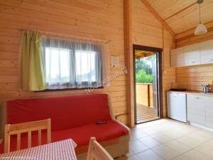uma sala de estar com um sofá vermelho e uma cozinha em Justmar em Mielenko