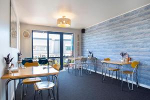 a restaurant with tables and chairs and a wooden wall at Harbourside Lodge in Nelson