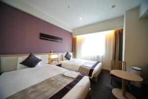 a hotel room with two beds and a window at Hotel Sunroute Asakusa in Tokyo