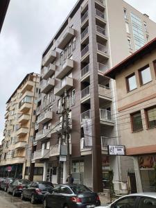 a large apartment building with cars parked in front of it at Apartment Prishtina in Prishtinë