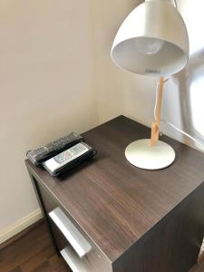 a desk with a lamp and a book on it at Torre Parque Apartamento in Morón