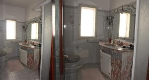 a bathroom with two sinks and two toilets at B&B Angolo Di Paradiso in Pellaro +16 photos