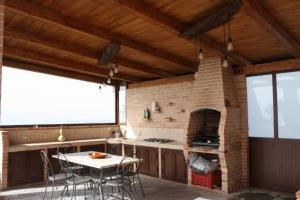 uma cozinha com uma mesa e um forno de tijolos em B&B Angolo Di Paradiso em Pellaro