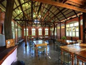 une grande chambre avec des tables et des chaises dans un bâtiment dans l'établissement Sanita Cottage, à Chom Bung