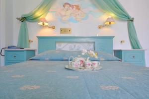 a bedroom with a bed with a blue bedspread with a mermaid mural at Villa Ianthia in Galaxidi