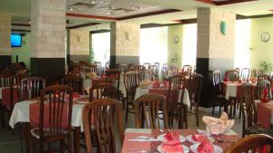 uma sala de jantar cheia de mesas e cadeiras em Stryama Balneohotel em Banya