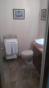 a bathroom with a toilet and a sink with towels at Bernache in Mont-Tremblant