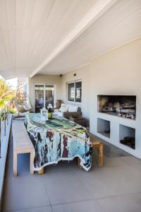 uma sala de estar com uma mesa e um sofá em Hilton Cove Beach House em Melkbosstrand