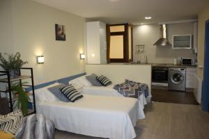 a living room with two beds and a kitchen at Casa Do Medio in Santiago de Compostela