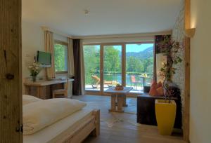 a bedroom with a bed and a living room with a balcony at Feuriger Tatzlwurm in Oberaudorf