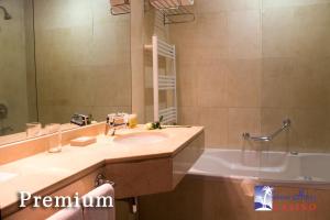 uma casa de banho com um lavatório, um espelho e uma banheira em Palmar Hotel Casino em Concordia